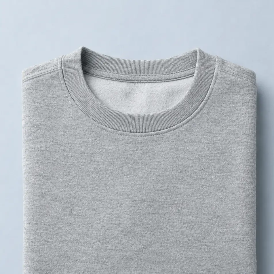 Sudadera gris jaspeado de cuello redondo doblada sobre fondo gris azulado